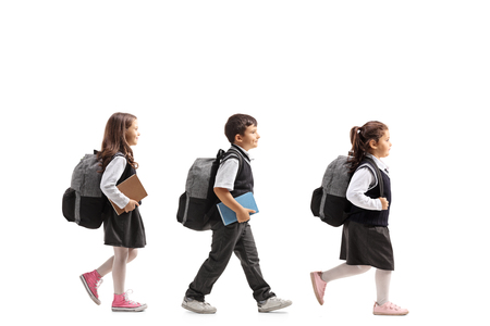 Full length profile shot of schoolchildren walking isolated on white backgroundの写真素材