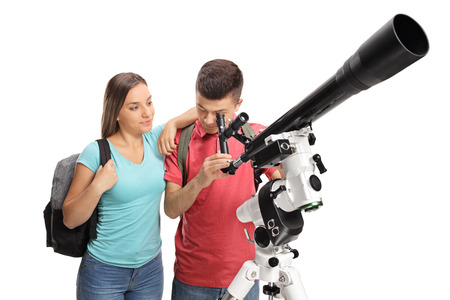 Teenage girl and a teenage boy looking through a telescope isolated on white background