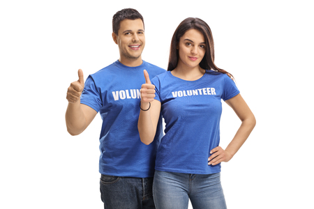 Young male and female volunteers smiling and showing thumbs up isolated on white backgroundの写真素材