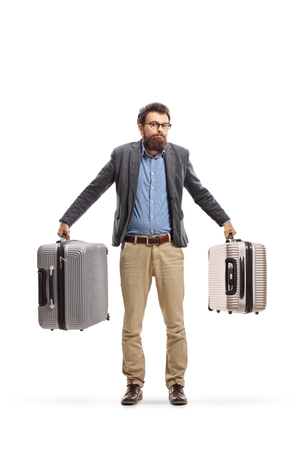 Full length portrait of a confused man holding suitcases isolated on white backgroundの写真素材