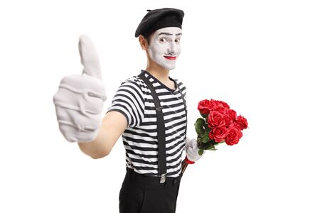 Mime holding a bunch of red roses showing thumbs up isolated on white backgroundの写真素材