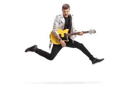 Full length shot of a young male guitarist jumping and playing isolated on whiteの写真素材