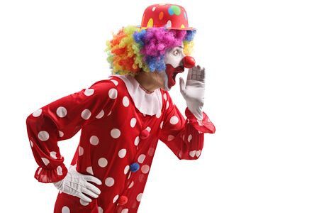 Profile shot of a surprised clown whispering isolated on whiteの写真素材