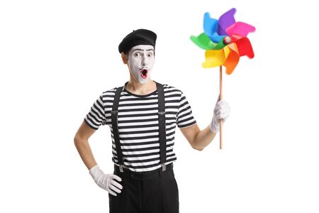Mime holding a spinning colorful pinwheel isolated on white backgroundの写真素材