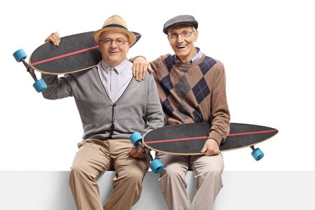 Senior men with longboards sitting on a panel isolated on white backgroundの写真素材