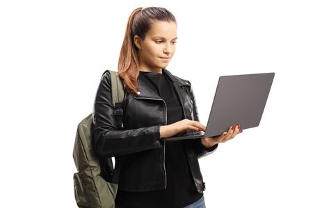 Female student standing and using a laptop computer isolated on white