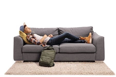 Male student sleeping on a sofa isolated on white backgroundの写真素材