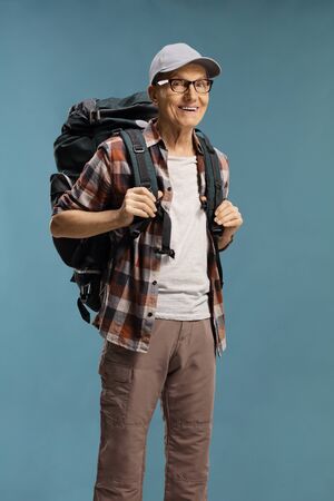 Elderly male hiker with a backpack over a blue background