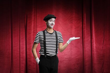 Mime performing a show on stage with red curtainsの写真素材