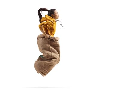 Young female jumping inside a sack isolated on white background