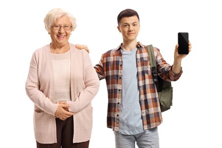 Elderly woman and a male student holding a mobile phone and posing isolated on white backgroundの写真素材