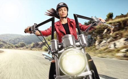 Young woman riding a custom motorbike on an open roadの写真素材