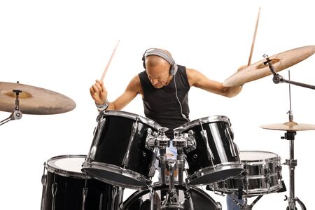 Man with headphones playing a drum set isolated on white backgroundの写真素材