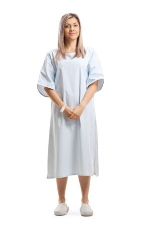 Full length portrait of a woman wearing a patient gown isolated on white backgroundの写真素材