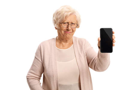 Grumpy elderly woman showing a mobile phone isolated on white background
