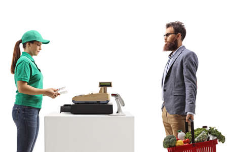 Bearded man with a shopping basket paying at a cash register isolated on white background