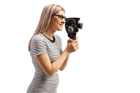 Profile shot of a young woman recording with a vintage 8 mm camera isolated on white background