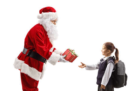 Santa Claus giving a sparkly present to a schoolgirl isolated on white backgroundの写真素材