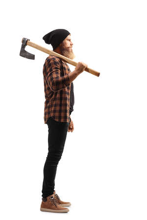 Full length profile shot of a young bearded man holding a hatchet on his shoulder isolated on white backgroundの写真素材