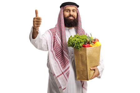 Arab man with a grocery bag standing and showing thumbs up isolated on white backgroundの写真素材