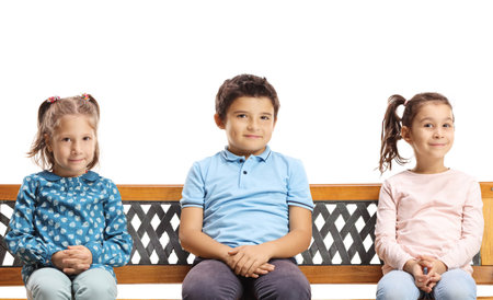 Children sitting on a bench isolated on white backgroundの写真素材