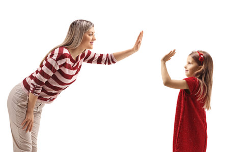 Woman making a high-five gesture with a girl in a red dress isolated on white backgroundの写真素材