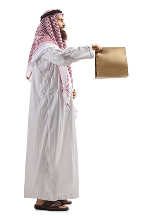 Saudi arab man holding a paper bag with takeaway food isolated on white backgroundの写真素材
