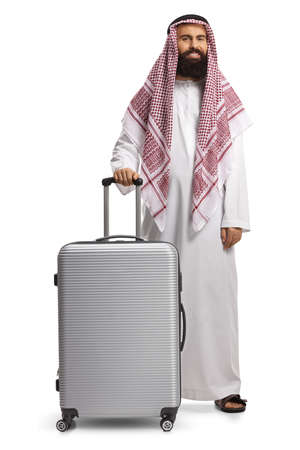 Full length portrait of an arab man in a thobe posing with a suitcase isolated on white backgroundの写真素材