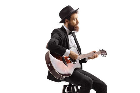 Bearded man sitting on a chair and playing an acoustic guitar isolated on white background