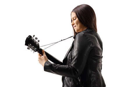Side shot of a young female with an acoustic guitar isolated on white background