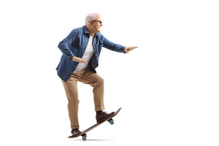 Full length profile shot of a mature man on a skateboard isolated on white backgroundの写真素材