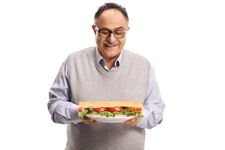 Cheerful mature man holding a plate with a sandwich isolated on white backgroundの写真素材