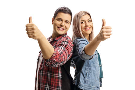 Young male and female posing back to back and gesturing thumbs up isolated on white background