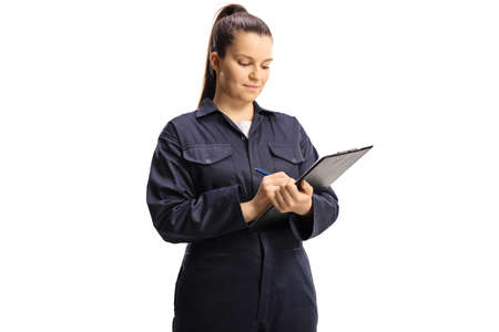 Female worker in a uniform writing on a clipboard isolated on white backgroundの写真素材