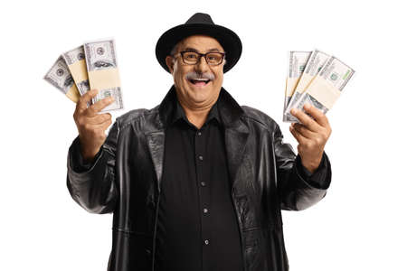 Elderly man in a leather coat and top hat holding bunch of money isolated on white background