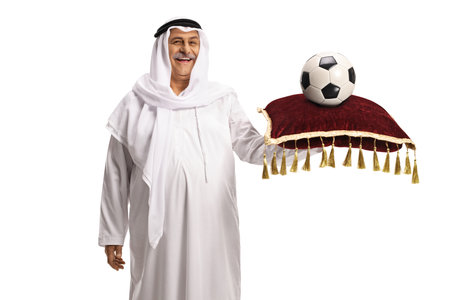 Mature arab man holding a football on a red velvet cushionの写真素材