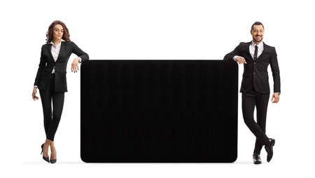 Businessman and businesswoman leaning on a black panel isolated on white backgroundの写真素材