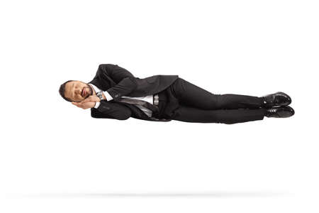 Businessman floating and sleeping in air isolated on white backgroundの写真素材