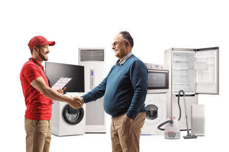 Shop assitant and a mature man doing handshake with electircal appliances in the back isolated on...