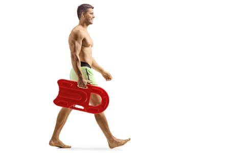 Full length shot of a swimmer walking and carrying a float isolated on white backgroundの写真素材