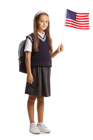 Full length portrait of a schoolgirl waving a small US flag isolated on white backgroundの写真素材