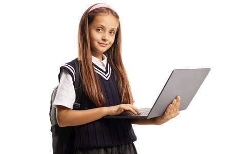 Pupil in a school uniform standing and using a laptop computer isolated on white backgroundの写真素材
