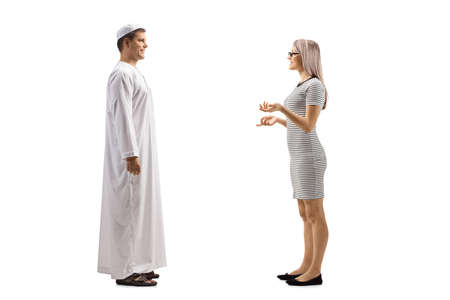 Full length profile shot of a woman talking to a young man in ethnic clothes isolated on white backgroundの写真素材