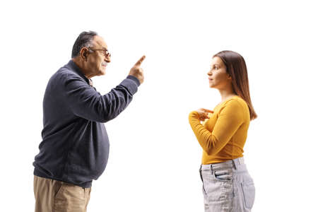 Profile shot of an angry mature man having an argument with a female teenager isolated on white backgroundの写真素材