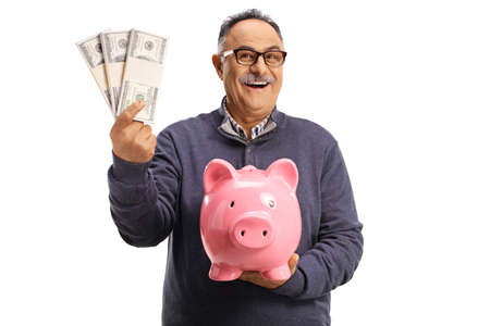 Mature man holding money and a piggy bank isolated on white backgroundの写真素材