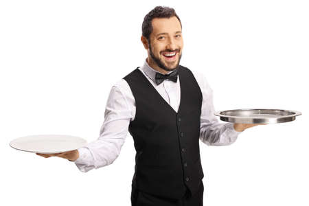 Smiling male server holding plates and a tray isolated on white backgroundの写真素材