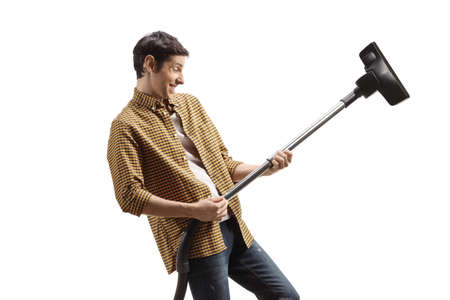 Happy young man playing a guitar with a vacuum cleaner isolated on white backgroundの写真素材