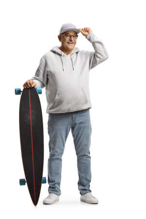 Full length portrait of a cheerful mature man greeting with a cap and holding a longboard isolated on white backgroundの写真素材