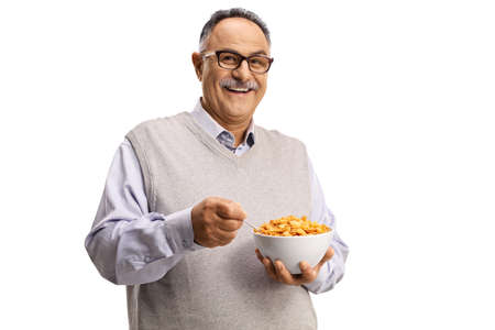 Smiling mature man holding a bowl of cornflakes isolated on white backgroundの写真素材