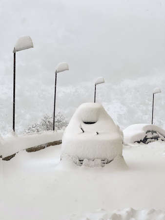 Winter shot of a suv covered in snow on a parking lotの写真素材
